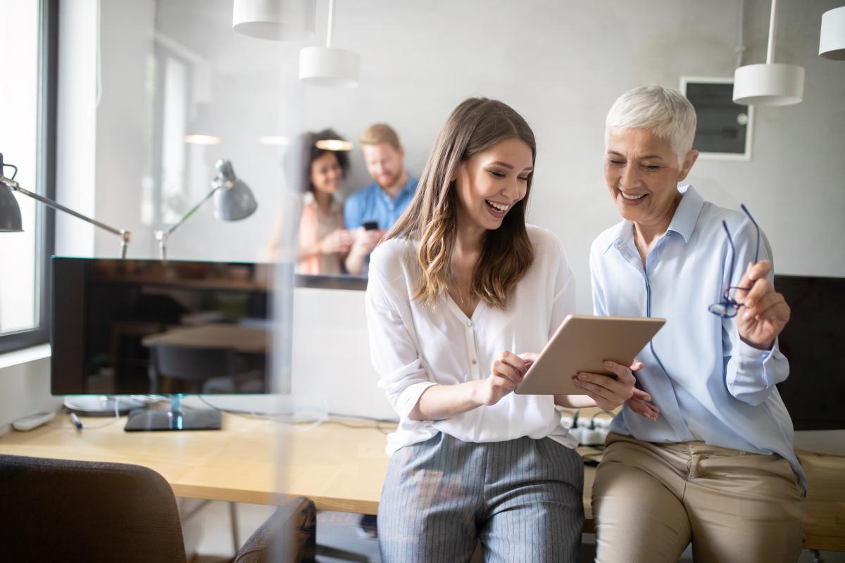 two women looking at a tablet