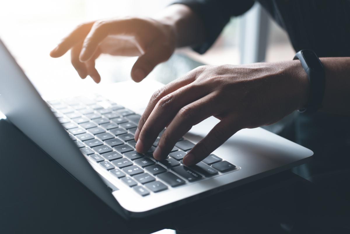 hands typing on a computer